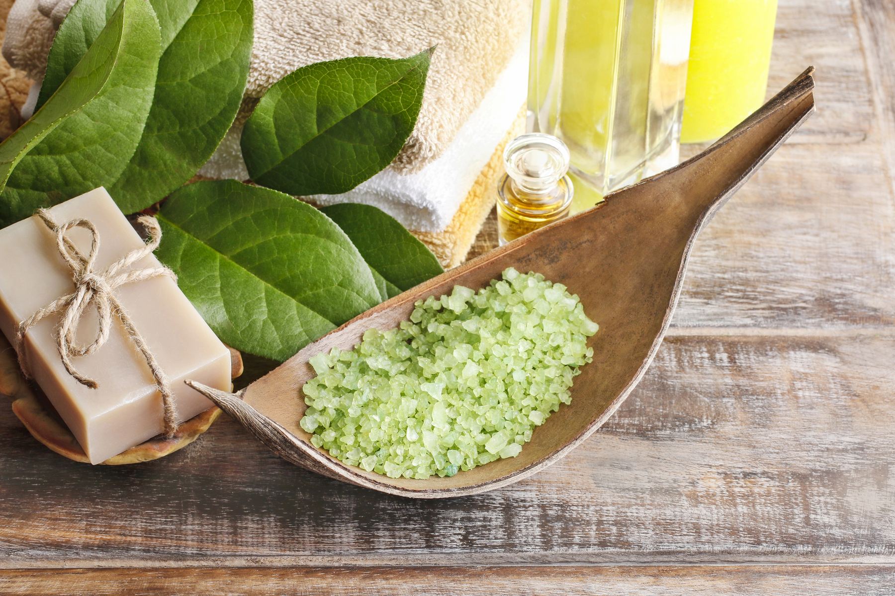 Natural oils, soap and leaves arranged on a wooden table, spa still life